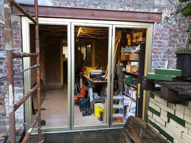 montageopening voor goudkleurig raam in renovatiewoning