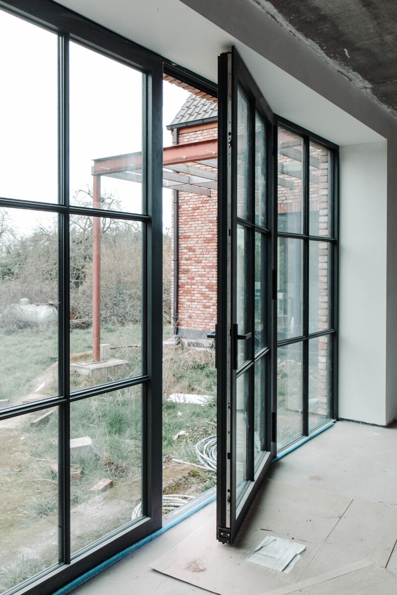 Zwarte aluminium ramen in moderne woning met veel lichtinval en strakke afwerking