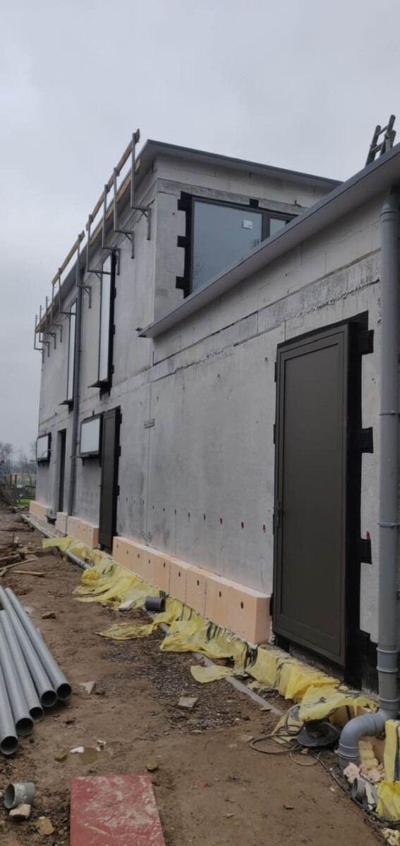 zijgevel met aluminium voordeur en strakke raamopeningen