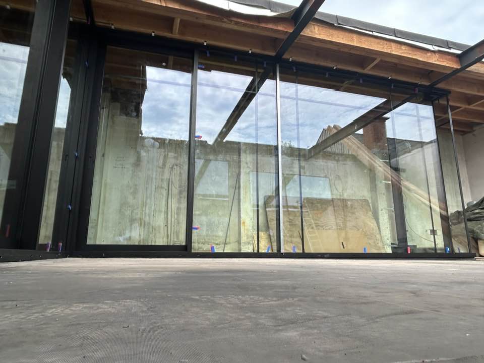 hoge glaswand met aluminium profielen in stedelijk pand