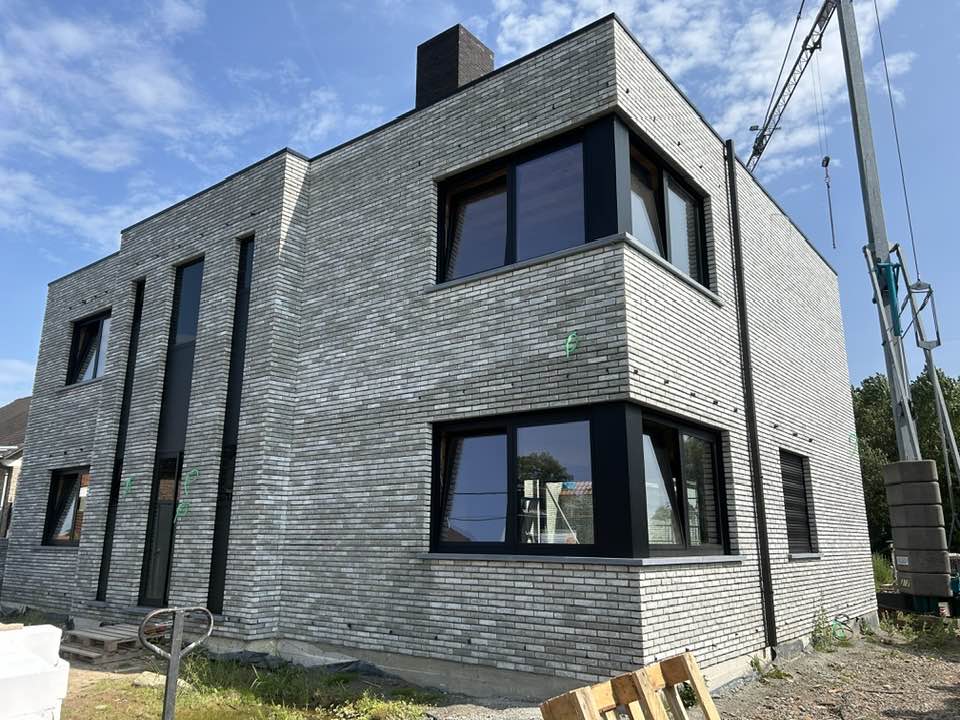 Donker aluminium raam in lichte gevelsteen