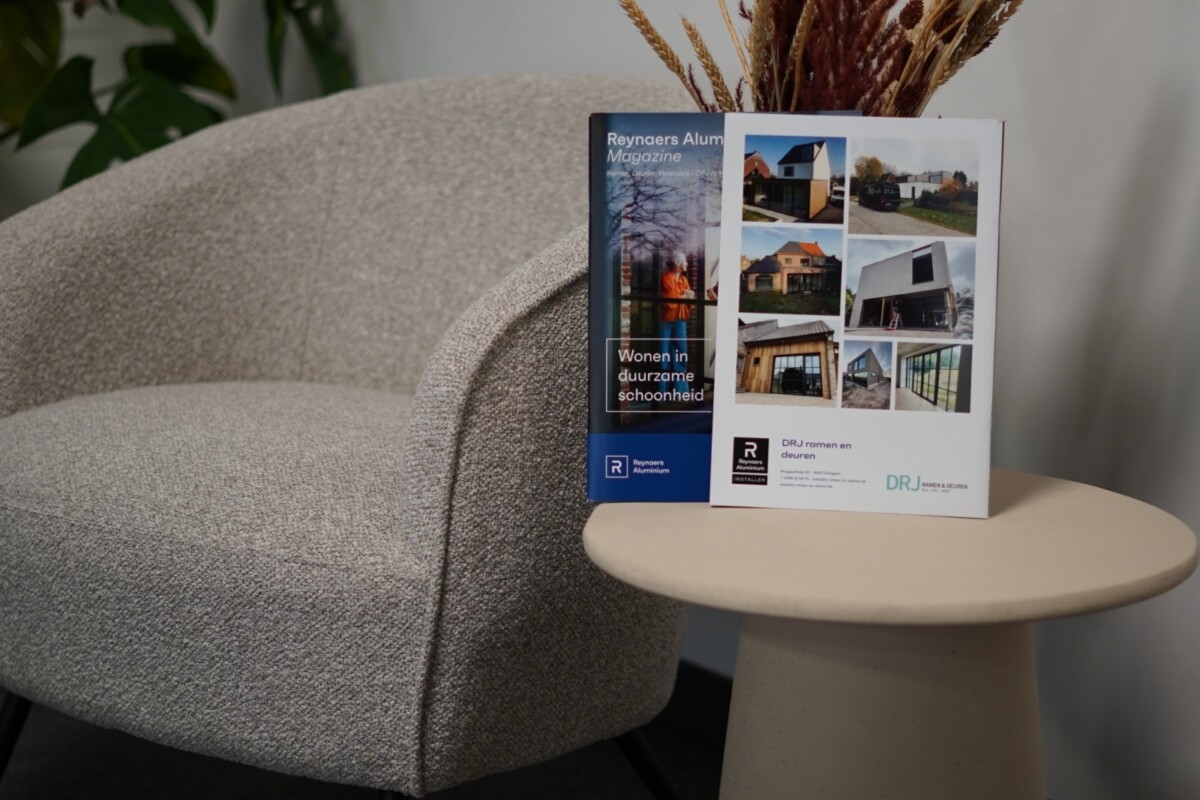 Brochure met realisaties van ramen en deuren in Lierde op tafel in showroom